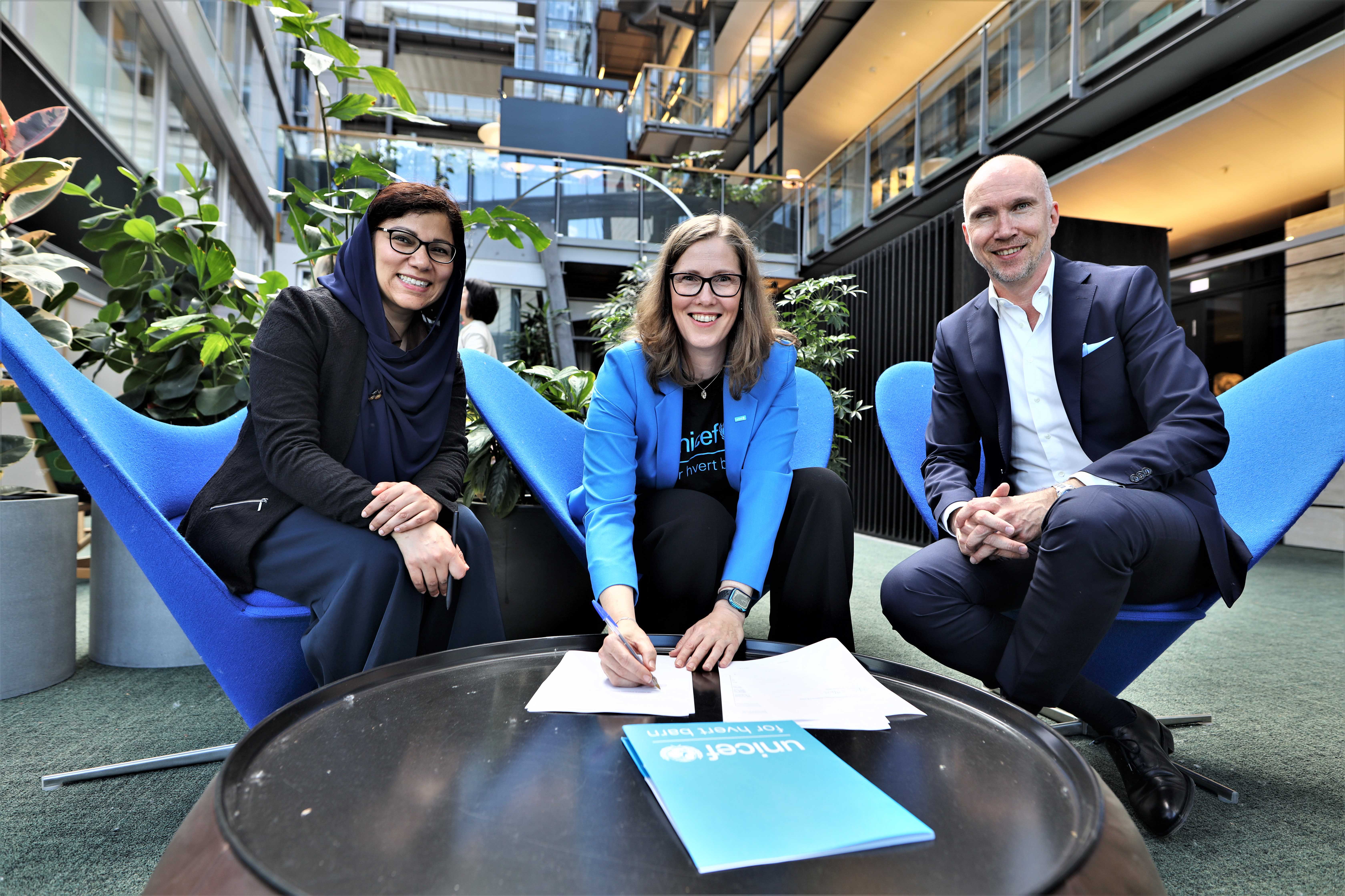 Three people looking into camera during contract signing